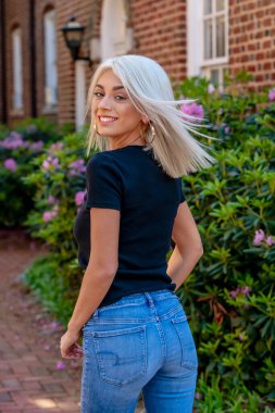 Sarışın bir model şehir ortamında poz veriyor.