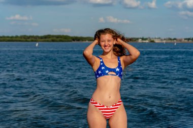 Güzel, koyu sarı bir bikini mankeni sahilde açık havanın tadını çıkarıyor.