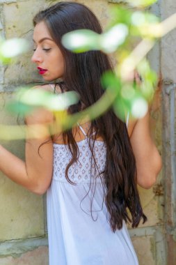 Muhteşem bir esmer model, açık havada bir bahar gününün tadını çıkarıyor. 