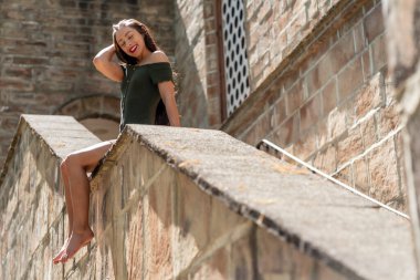 Muhteşem bir esmer model, açık havada bir bahar gününün tadını çıkarıyor. 