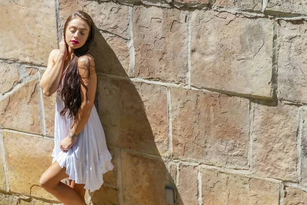 Muhteşem bir esmer model, açık havada bir bahar gününün tadını çıkarıyor. 