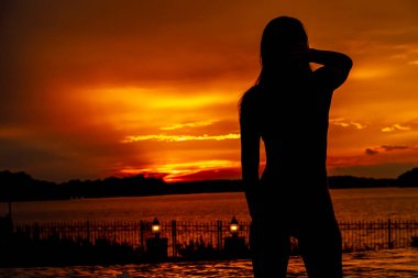 Güzel bir İspanyol esmer mayo mankeni Kaliforniya sahilinde günbatımının tadını çıkarıyor.