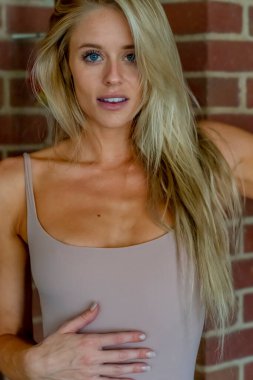 Sarışın bir model şehir ortamında iç çamaşırlarıyla poz veriyor.