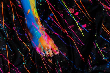 Çıplak bir kadın ev ortamında renkli boya ile boyanır.