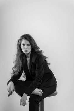 Stüdyo ortamında güzel bir karma ırk modeli iş elbisesi içinde poz verir.