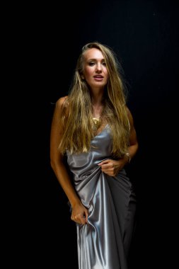 Muhteşem sarışın bir model stüdyo ortamında poz veriyor.