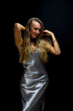 Muhteşem sarışın bir model stüdyo ortamında poz veriyor.