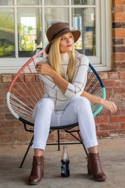 Sonbahar kıyafetleriyle dışarıda poz veren güzel bir sarışın manken.