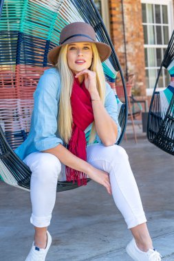 Sonbahar kıyafetleriyle dışarıda poz veren güzel bir sarışın manken.