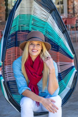 Sonbahar kıyafetleriyle dışarıda poz veren güzel bir sarışın manken.