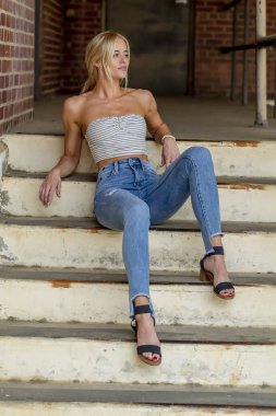 Sarışın bir model şehir ortamında poz veriyor.