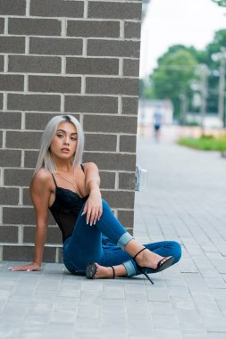 Sarışın bir model şehir ortamında poz veriyor.