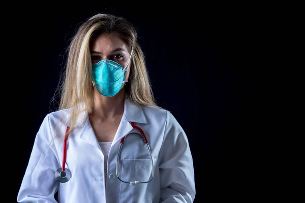 A young doctor poses with a N95 mask in a studio environment