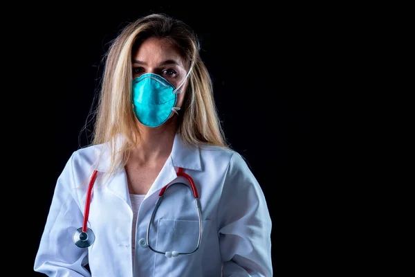 A young doctor poses with a N95 mask in a studio environment