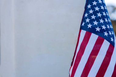 Askeri mezarlıkta ölen bir kahramanın önünde küçük bir Amerikan bayrağı duruyor.