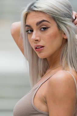 Sarışın bir model şehir ortamında poz veriyor.