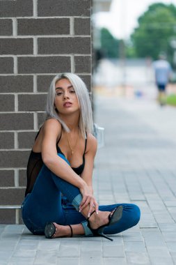 Sarışın bir model şehir ortamında poz veriyor.