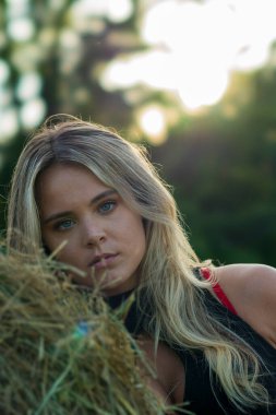 Sarışın bir çiftçinin kızı çiftlik ortamında poz veriyor.