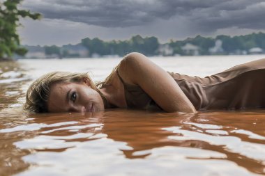 Muhteşem sarışın bir model gölde güzel bir gün geçiriyor.