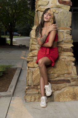 Muhteşem bir esmer model yaz havasının tadını çıkarırken dışarıda poz veriyor.