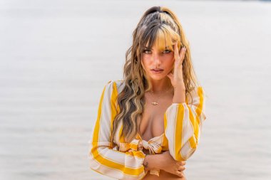 Muhteşem bir esmer model göl kenarındaki yaz havasının tadını çıkarıyor.