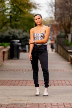 Muhteşem bir esmer model bahar havasının tadını çıkarırken dışarıda poz veriyor.