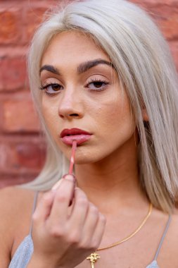 Sarışın bir model şehir ortamında poz veriyor.