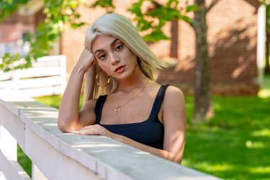 Sarışın bir model şehir ortamında poz veriyor.