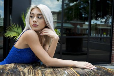 Sarışın bir model şehir ortamında poz veriyor.