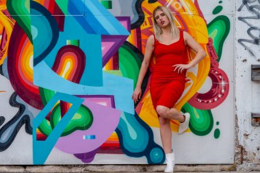 Sonbahar kıyafetleriyle dışarıda poz veren güzel bir sarışın manken.