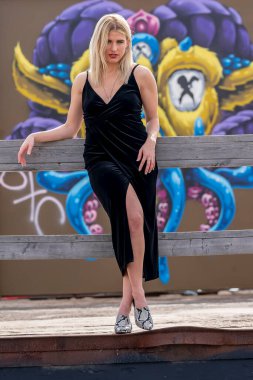 Sonbahar kıyafetleriyle dışarıda poz veren güzel bir sarışın manken.