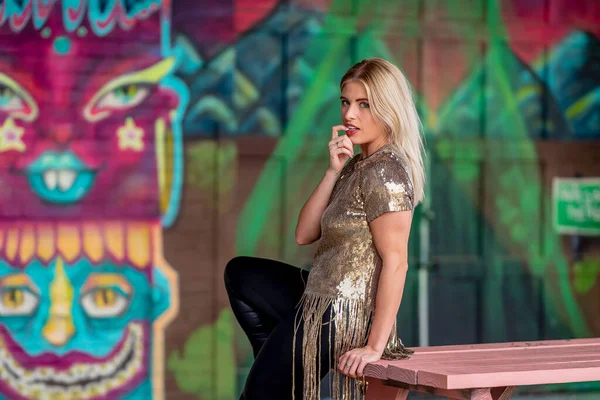 Sonbahar kıyafetleriyle dışarıda poz veren güzel bir sarışın manken.