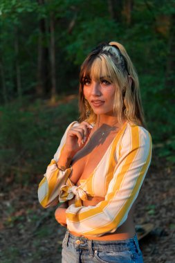 Muhteşem bir esmer model yaz havasının tadını çıkarırken dışarıda poz veriyor.