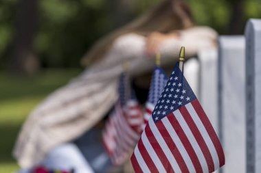 Genç bir gelin kederini askeri mezarlıktaki bir aile üyesinin mezarında gösterir.