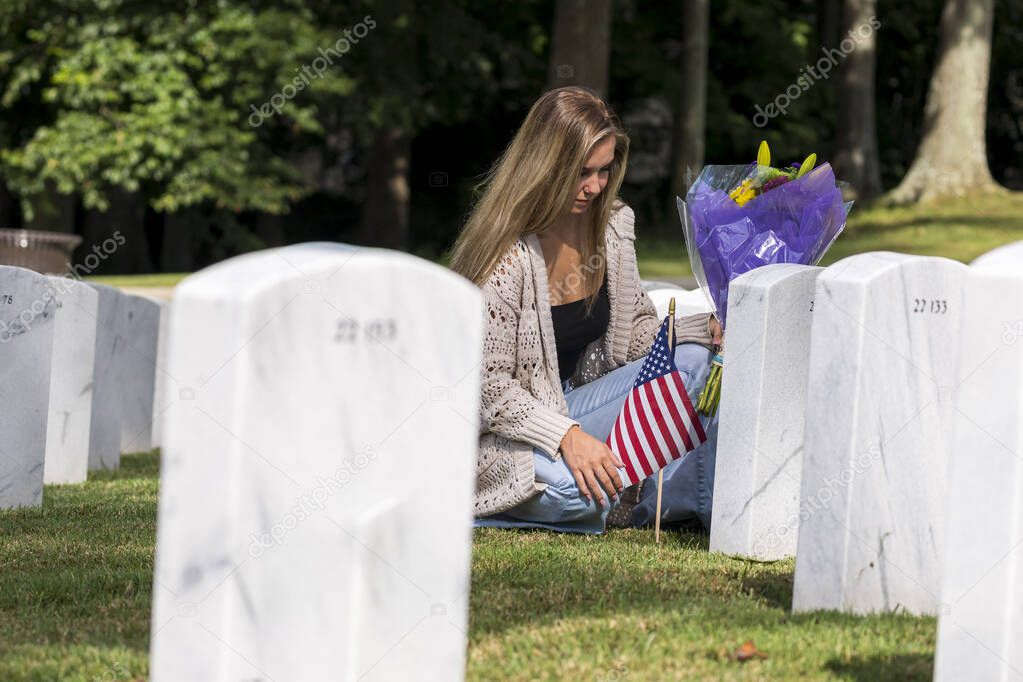 A young bride shows her grief at the burial site of a family member at a military cemetery