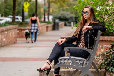 Muhteşem bir esmer model bahar havasının tadını çıkarırken dışarıda poz veriyor.