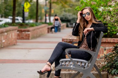 Muhteşem bir esmer model bahar havasının tadını çıkarırken dışarıda poz veriyor.