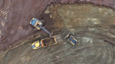 Buldozerler ve kazıcıların toprağı temizlediği, enkaz taşıyan kamyonların ve gelecekteki büyük depo yapılarının ana hatlarını belirleyen işaretli temellerin bulunduğu uçsuz bucaksız bir inşaat alanının havadan görüntüsü..
