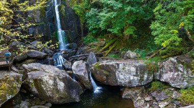 Yapraklar sonbahara doğru değişmeye başlarken dağlık bir ortamda güzel bir şelale kurulur..