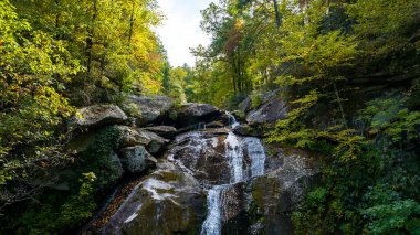 Yapraklar sonbahara doğru değişmeye başlarken dağlık bir ortamda güzel bir şelale kurulur..