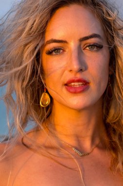 Çekici sarışın bir model, sakin bir Meksika plajında güven içinde poz veriyor. Güzelliği altın kum, nazik dalgalar ve nefes kesen doğal zarafetin sergilenen sıcak tropikal esintisiyle uyum içinde..