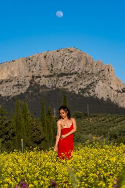 Çekici, çıplak bir Avrupalı model, İspanyol kır çiçeklerinin arasında yaz sonlarındaki parlaklığın tadını çıkarıyor. Doğanın güzelliğini zarafetle somutlaştırıyor..