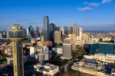 Dallas 'ın havadan görünüşü, ikonik silueti, geniş otoyolları ve genişleyen banliyöleriyle geniş, canlı bir metropolü gösteriyor. DFW bölgesini sanayi, ulaşım ve kültürün büyük bir iç merkezi olarak vurguluyor..