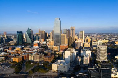 Dallas 'ın havadan görünüşü, ikonik silueti, geniş otoyolları ve genişleyen banliyöleriyle geniş, canlı bir metropolü gösteriyor. DFW bölgesini sanayi, ulaşım ve kültürün büyük bir iç merkezi olarak vurguluyor..