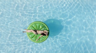 Muhteşem bir esmer bikini modeli Karayipler 'de bir havuz kenarında güneşleniyor ve nazik Tradewind' leri emiyor. Altın tenini mükemmelleştirirken sıcaklığın, huzurun ve tropikal titreşimlerin tadını çıkarıyor..