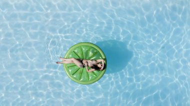 Muhteşem bir esmer bikini modeli Karayipler 'de bir havuz kenarında güneşleniyor ve nazik Tradewind' leri emiyor. Altın tenini mükemmelleştirirken sıcaklığın, huzurun ve tropikal titreşimlerin tadını çıkarıyor..