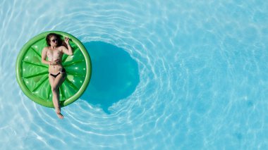 Muhteşem bir esmer bikini modeli Karayipler 'de bir havuz kenarında güneşleniyor ve nazik Tradewind' leri emiyor. Altın tenini mükemmelleştirirken sıcaklığın, huzurun ve tropikal titreşimlerin tadını çıkarıyor..