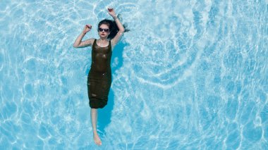 Muhteşem bir esmer bikini modeli Karayipler 'de bir havuz kenarında güneşleniyor ve nazik Tradewind' leri emiyor. Altın tenini mükemmelleştirirken sıcaklığın, huzurun ve tropikal titreşimlerin tadını çıkarıyor..