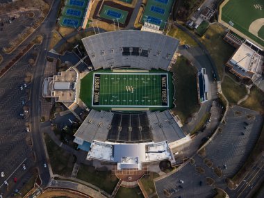 Federal Kredi Birliği Stadyumu 'nun hava görüntülerine göre Wake Forest 31,500 koltuklu futbol sahası, Gene Hooks sahasının yakınında yer alıyor. Şeytan Deacons tarihi Batı Kampüsü atletizm kompleksi de göz önünde..