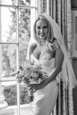 Işıl ışıl bir gelin zarif bir şekilde gelinliğiyle poz verir. Geleceğin özel gününün güzelliği, heyecanı ve neşe dolu zamansız gelin portrelerini çeker..